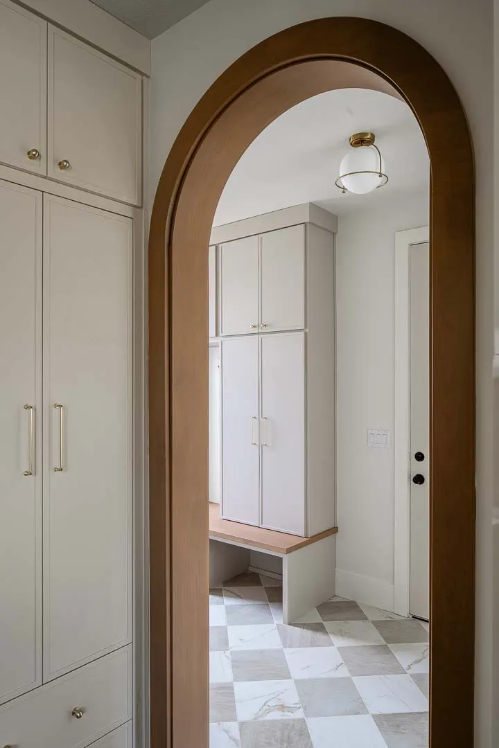 Arched doorway to a mudroom with a checkered floor